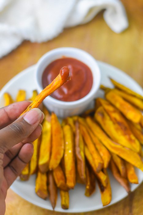dipping sweet potato fry in ketchup