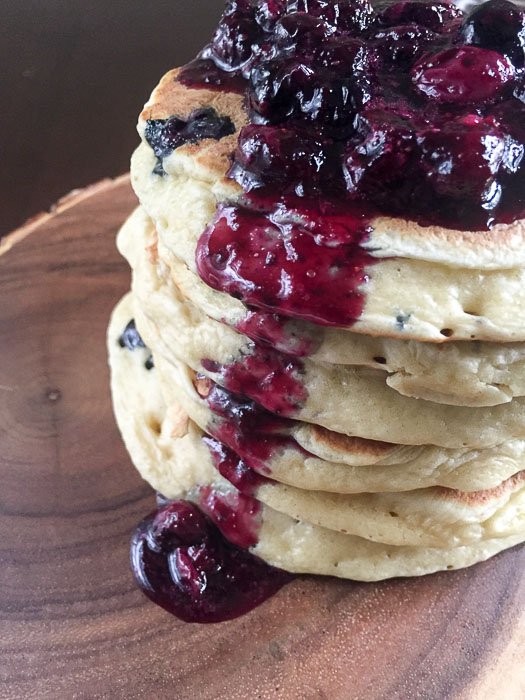 stack of blueberry pancakes topped with lots of blueberry compote
