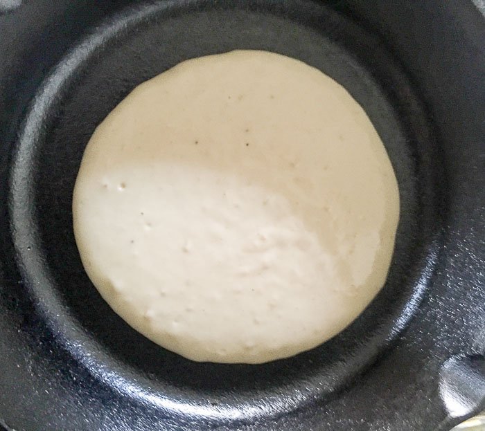 cooking pancake in cast iron skillet.