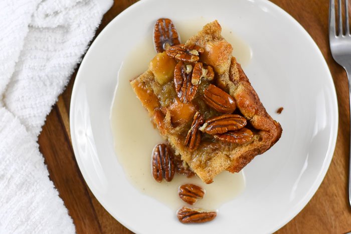 piece of bread pudding topped with pecan halves and vanilla glaze