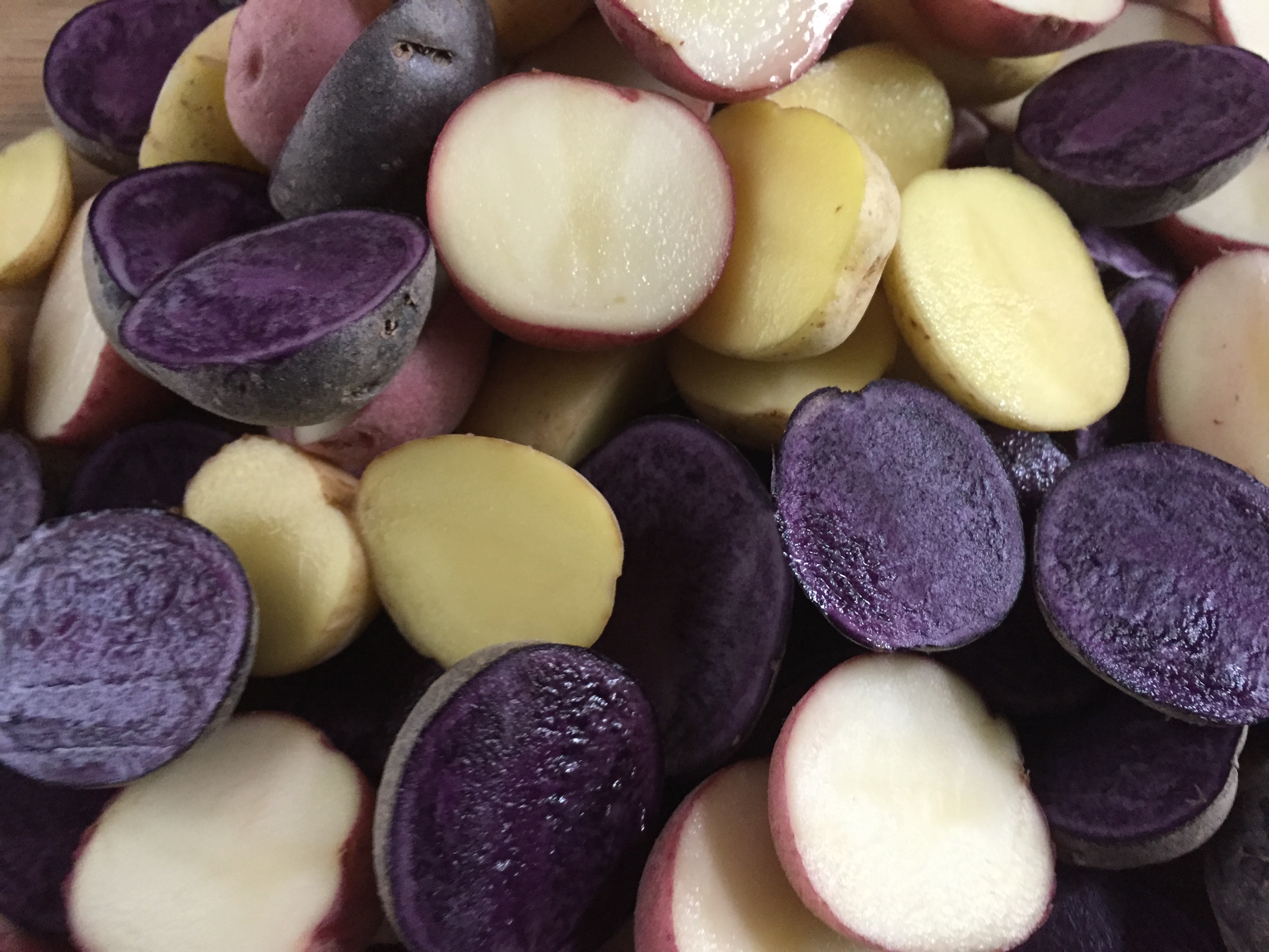 purple, red, and yellow baby potatoes cut in halves
