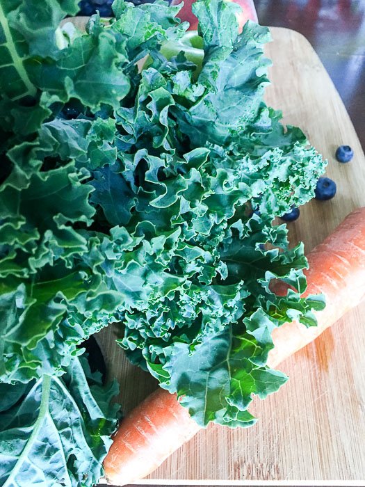 fresh kale and other produce on cutting board