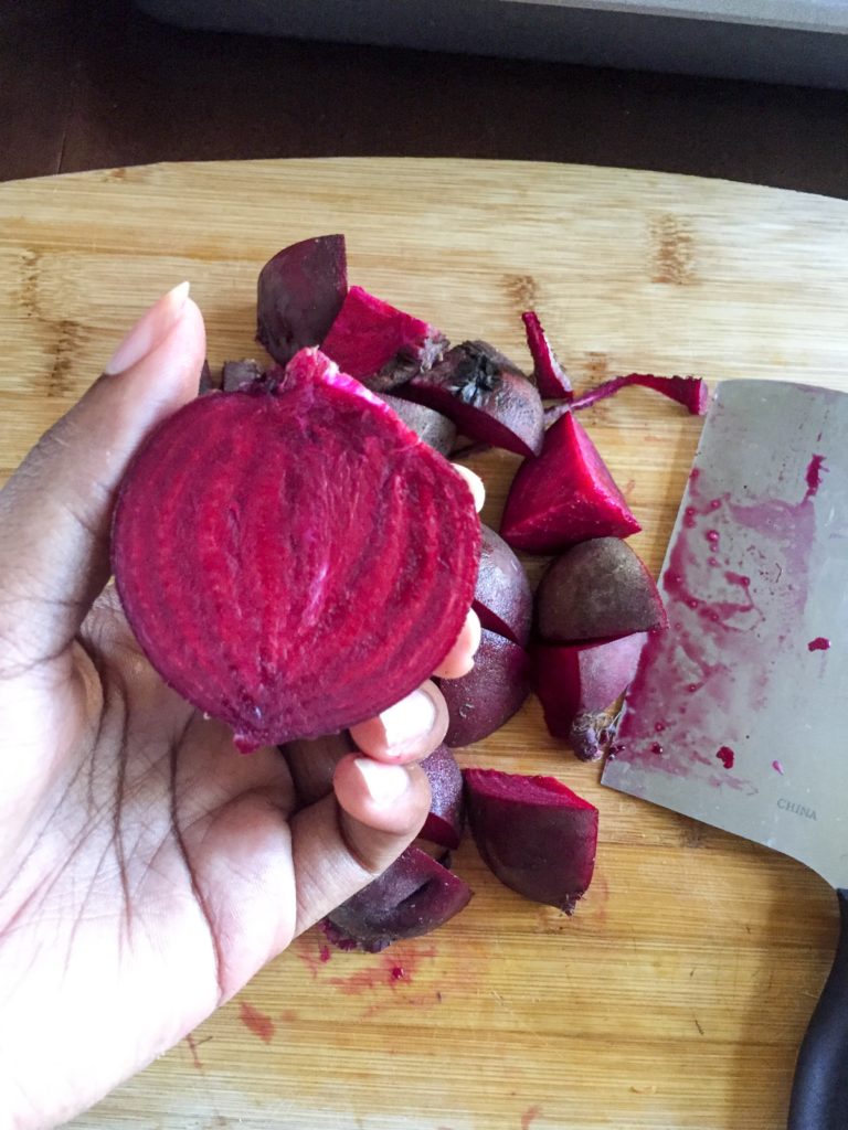 holding trimmed beet cut in half