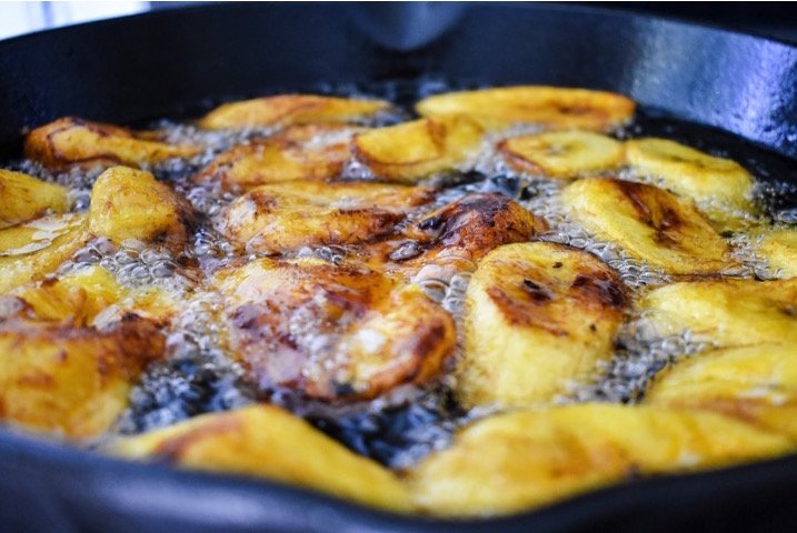 slices of sweet plantain frying in hot oil.