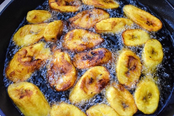 sliced plantain frying in oil.