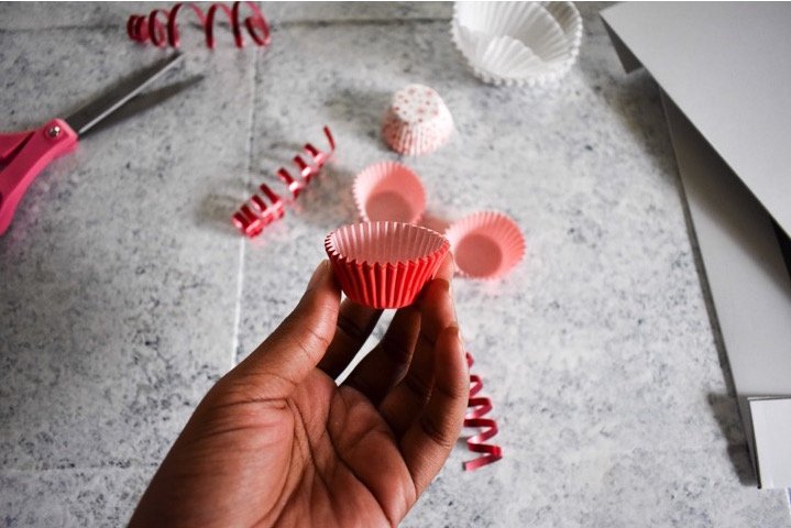 holding mini red cupcake liner