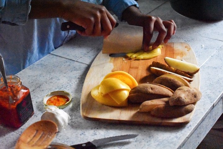 slicing preserved lemon peels on wooden cutting board.