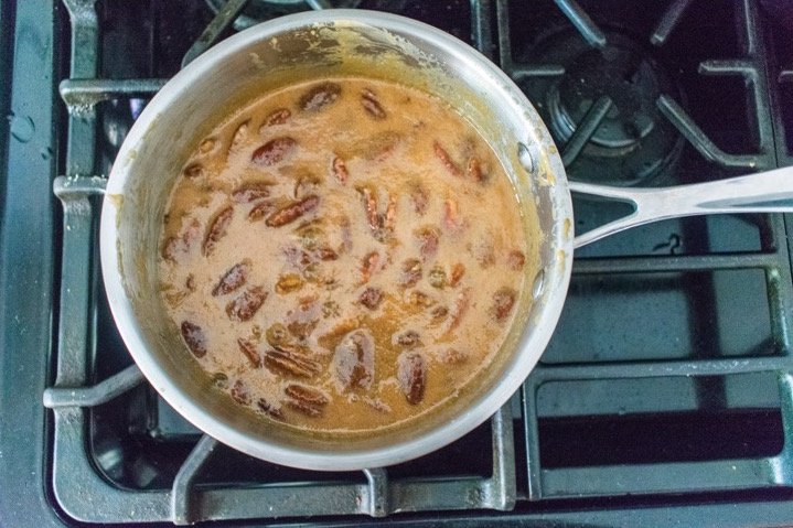 brown sugar pecan praline sauce in small stainless steel saucepan.
