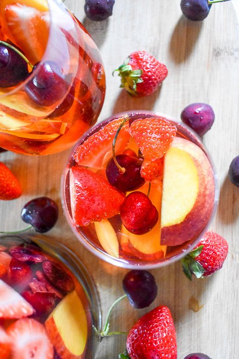 glasses of rosé sangria surrounded by fresh fruit