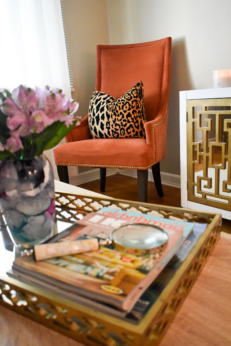A look inside the entertaining-friendly living room of Food Blogger and Southern "hostess with the mostest" in her 1950s ranch-style home. Classic and modern design elements are married along with pops of color, print, and, texture, local art, and a balance of metallic and neutral furniture and accents in this living room tour seen on Dash of Jazz