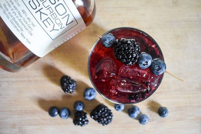 The bubbly bourbon & berries cocktail is a deliciously fun drink made simply with bourbon whiskey, champagne, and black and blueberries.