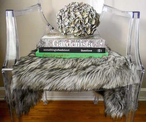coffee table books, antique hydrangea, and fur seat cover on ghost chair
