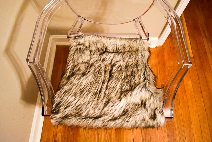 A DIY faux fur seat covers tutorial to inexpensively style ghost chairs anywhere in your space for a luxurious touch on a budget as part of the One Room Challenge. by Dash of Jazz
