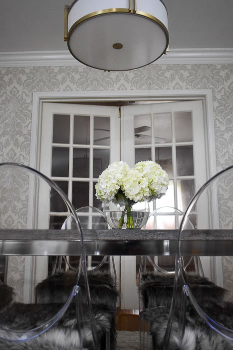 hydrangeas on gray dining table surrounded by ghost chairs