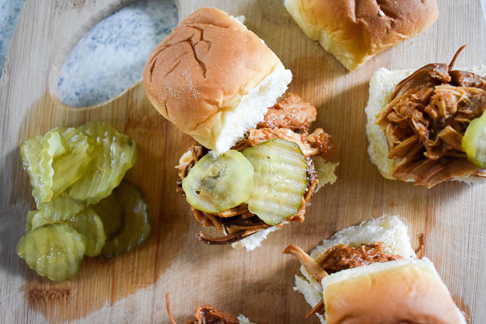 overhead view of slow cooker pulled bbq chicken sliders on a cutting board
