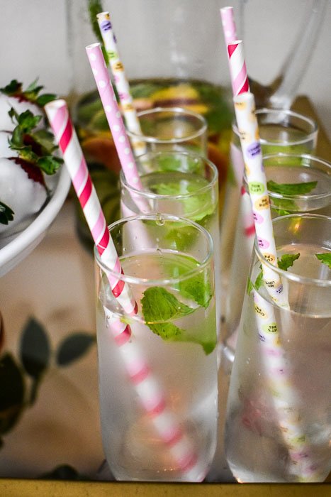 stemless wine glasses filled with infused water and colorful paper straws