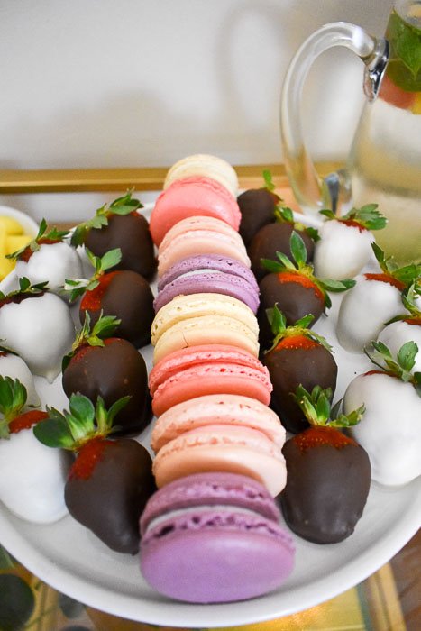 macarons and chocolate covered strawberries on cake stand