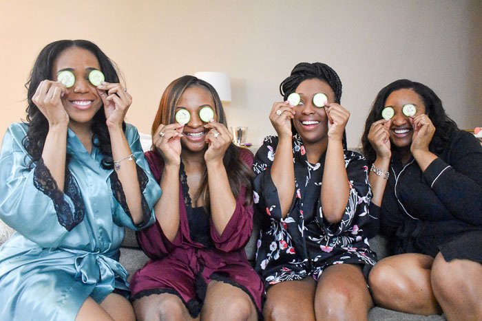 women placing cucumber slices on eyes for at-home spa treatment