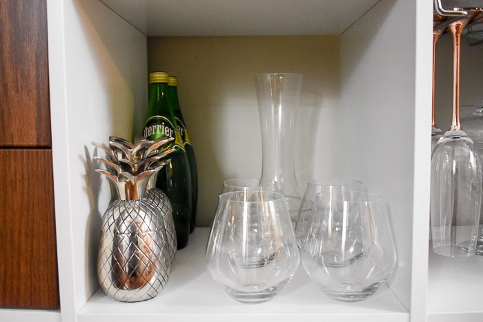 wine and cocktail glasses on a home bar cabinet shelf