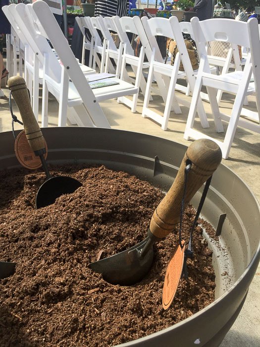 two small trowels in a large pot of soil