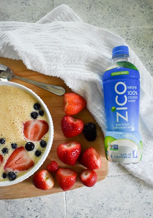 hulled strawberries between a bottle of ZICO coconut water and a smoothie bowl