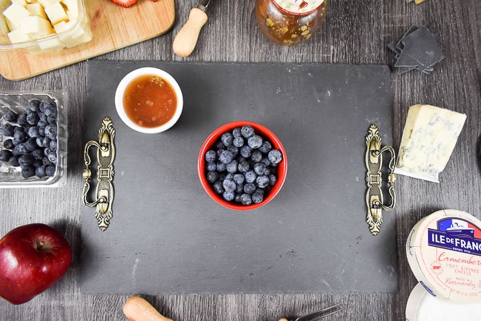 berries and honey on slate cheese board