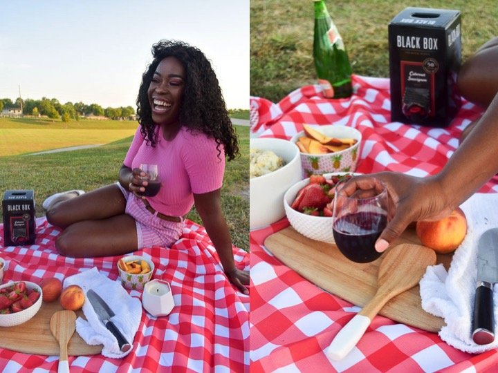 woman in pink holding red wine at outdoor picnic