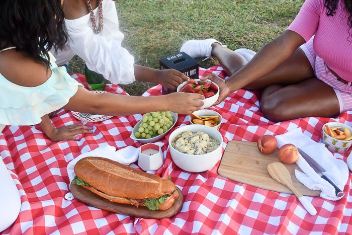 women sharing food at picnic