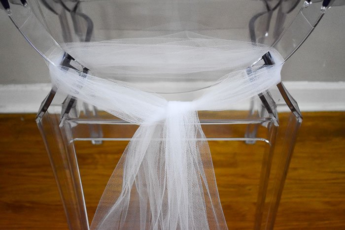 ghost chair decorated with white tulle