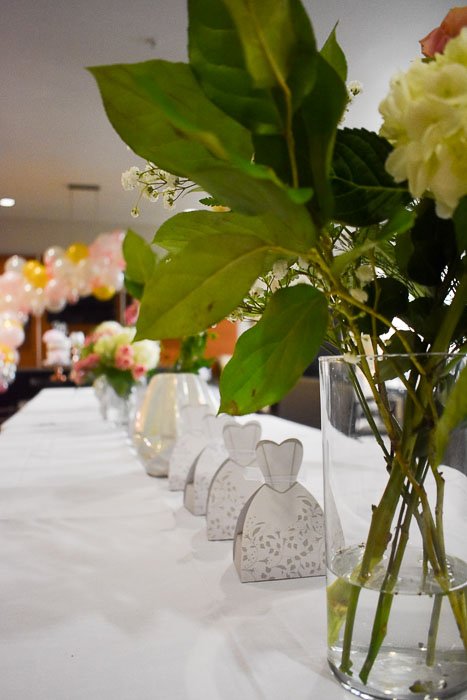 floral arrangement and party favors on table at bridal shower