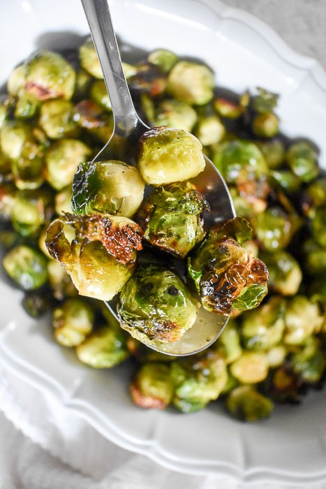 serving brussels sprouts on silver spoon.