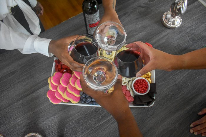 toasting sparkling water and red wine over dessert board