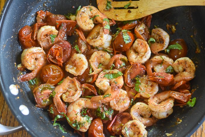 sauteed shrimp and tomatoes with fresh basil in skillet