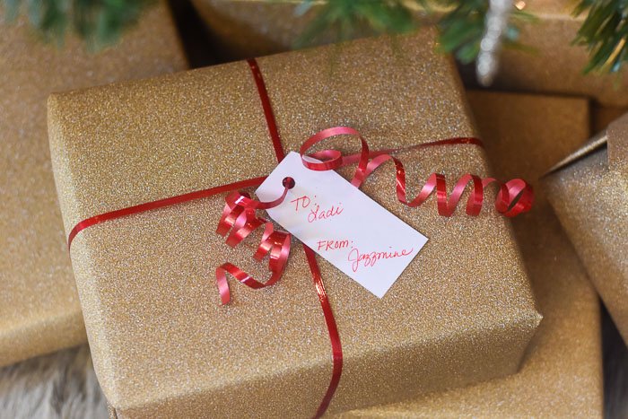 presents wrapped in gold glitter paper under Christmas tree