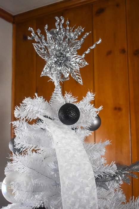 silver glitter Christmas tree topper on white tree