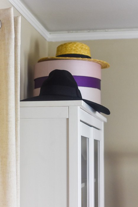 hats and hatboxes styled on bookshelf