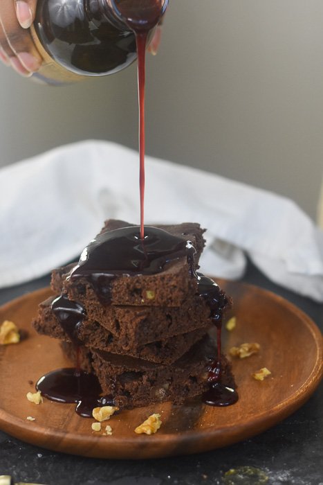 pouring syrup over baked dark chocolate pancakes