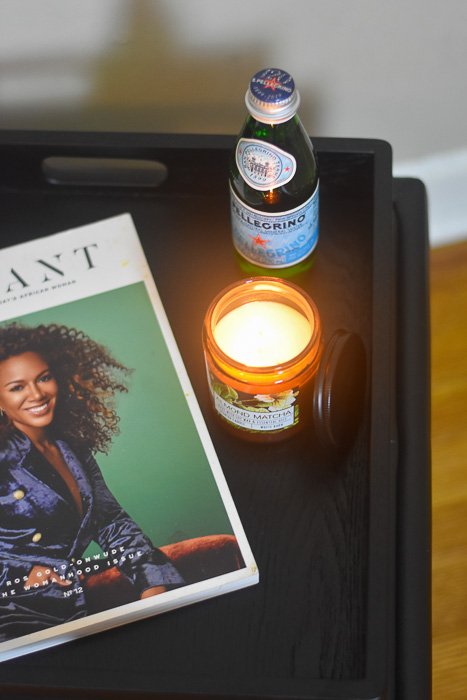 tray with candle, magazine, and bottle of water