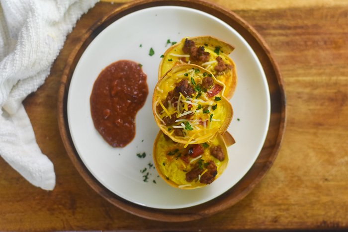 three mini breakfast taco egg cups on plate with salsa.