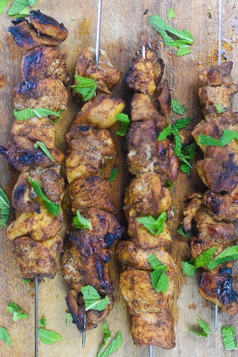 Moroccan-spiced grilled chicken skewers garnished with mint