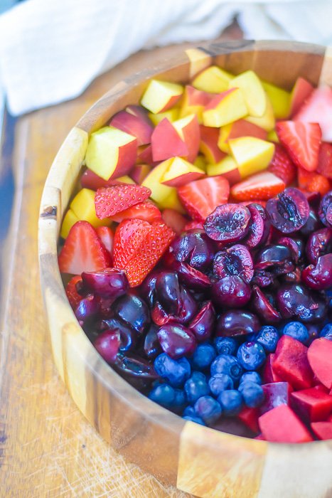 bowl of peaches, strawberries, cherries, blueberries, and plums
