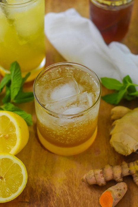 sparkling turmeric gingerade in glass over ice