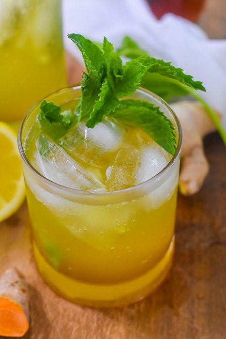 anti-inflammatory mocktail with ginger syrup garnished with stem of fresh mint.