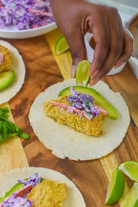 squeezing fresh lime over fish taco