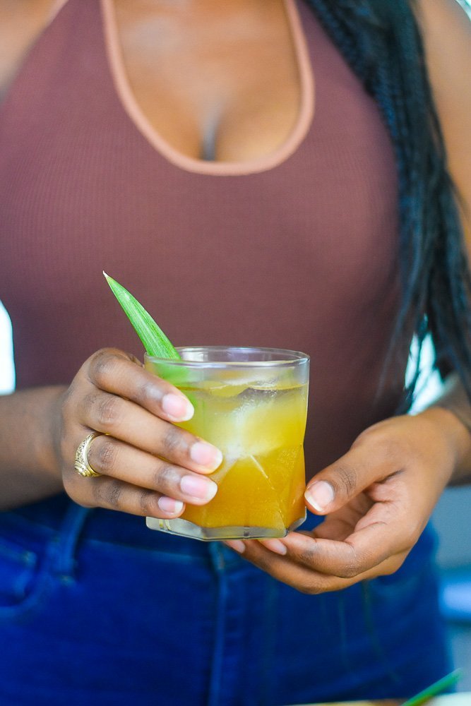 Jazzmine holding spiced brown sugar pineapple whiskey cocktail.