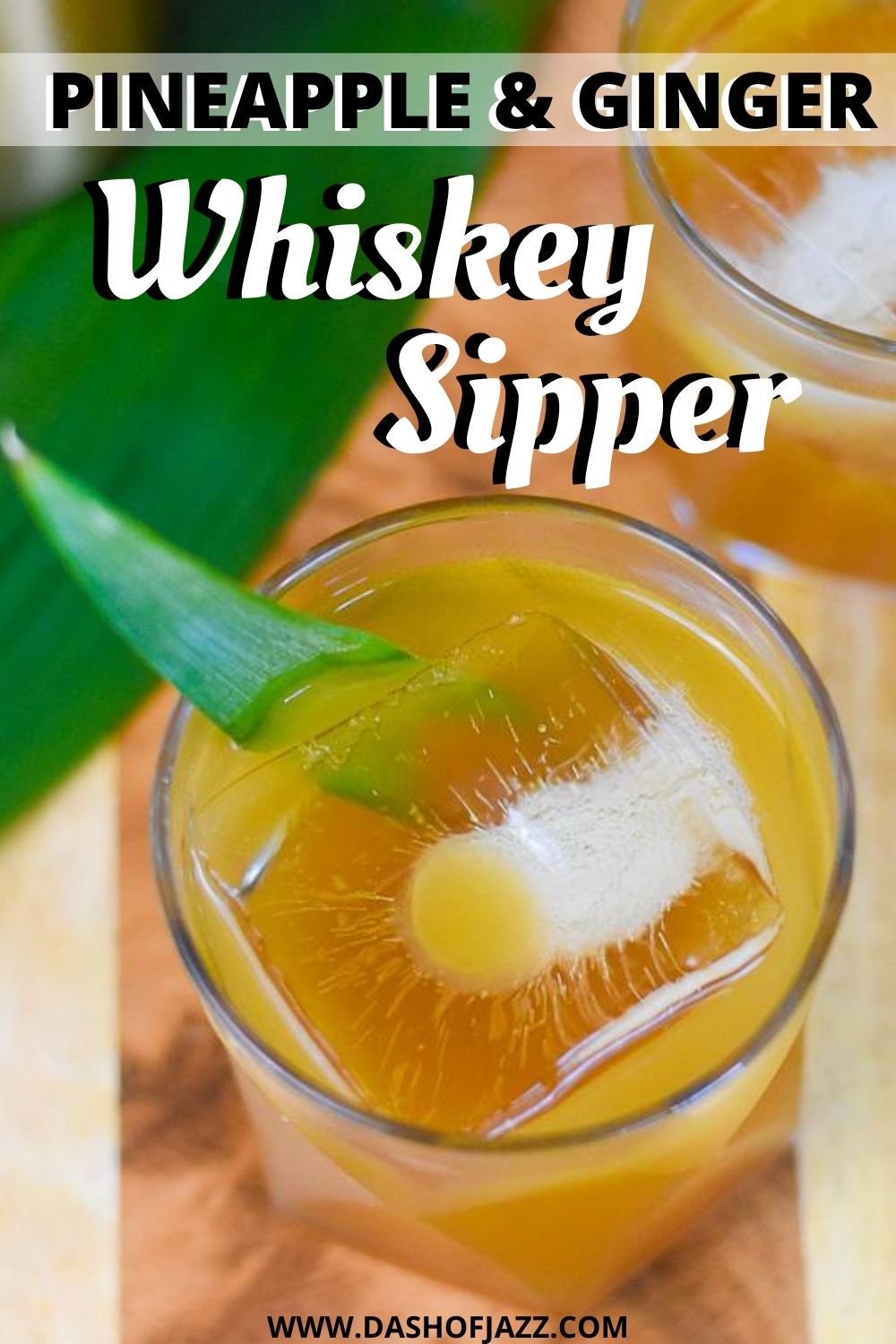 overhead of cocktail in glass over large ice cube with text overlay "pineapple & ginger whiskey sipper"