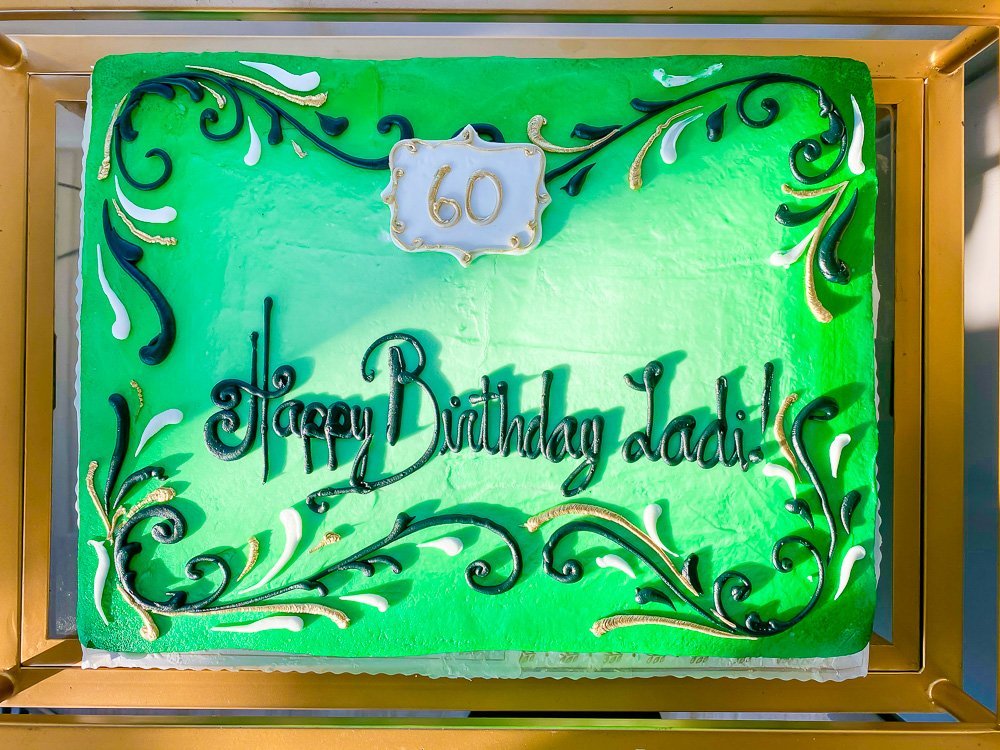 green airbrushed half sheet cake reading "Happy Birthday Ladi"