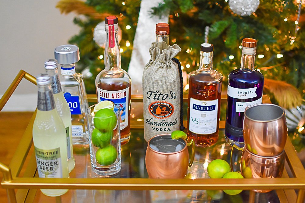 assorted liquors and ingredients for mule cocktails on top of bar cart