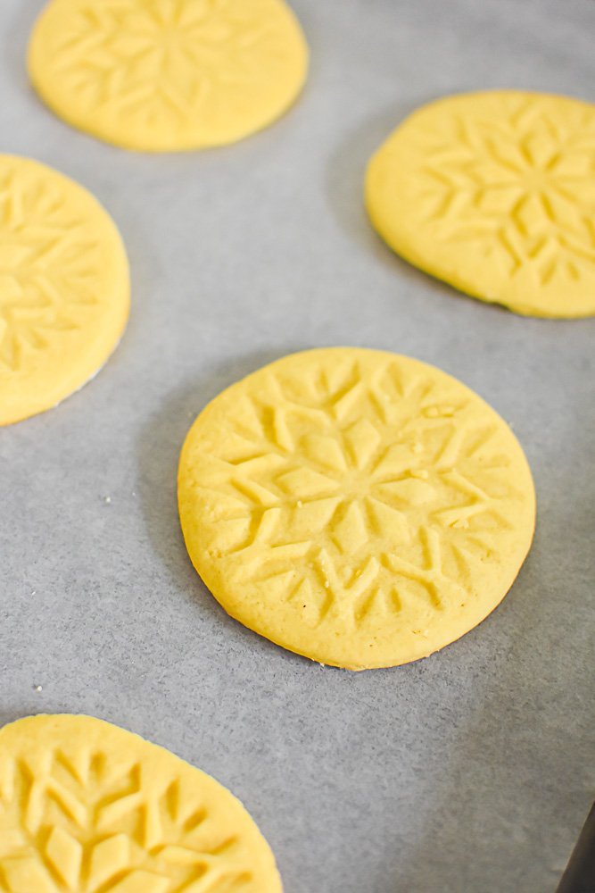 stamped sugar cookies on parchment-lined cookie sheet