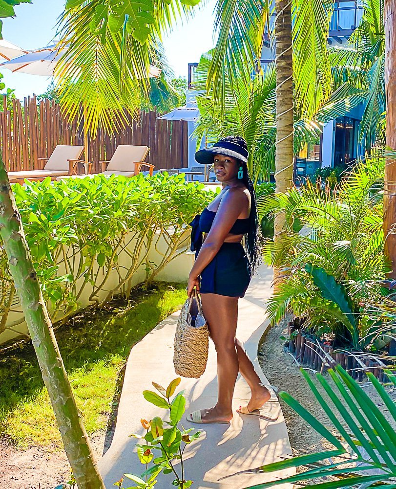 Jazzmine holding straw beach bag on  deck of Isla Holbox resort pool
